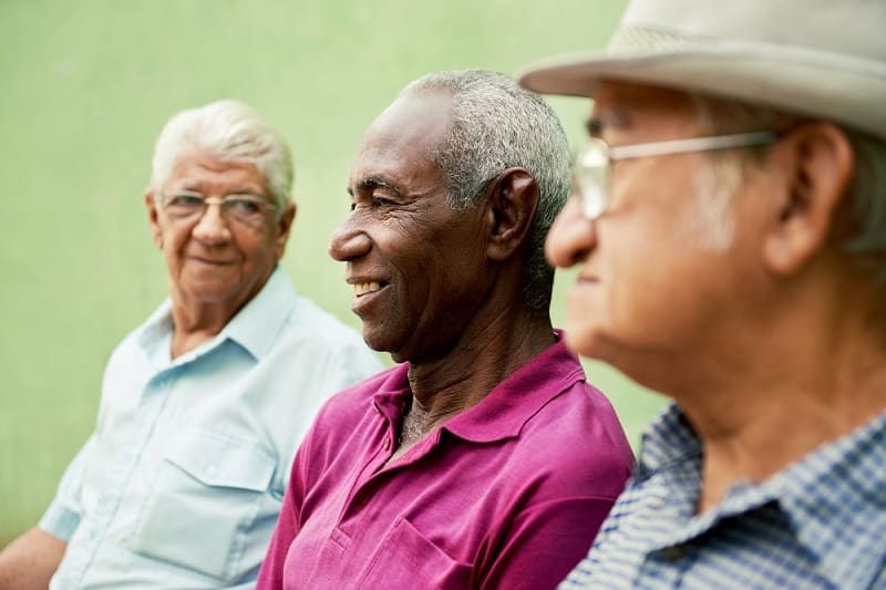 Três homens idosos sorrindo. Imagem para ilustrar a matéria sobre tipos de envelhecimento