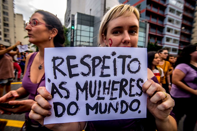 Mulheres em uma marcha. Uma mulher segura uma placa com a frase "Respeiro às mulheres do mundo". Imagem para ilustrar a matéria sobre Dia Internacional da Mulher